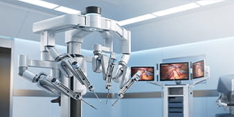 Robotic surgical system with multiple articulated arms suspended over an operating table in a hospital OR.